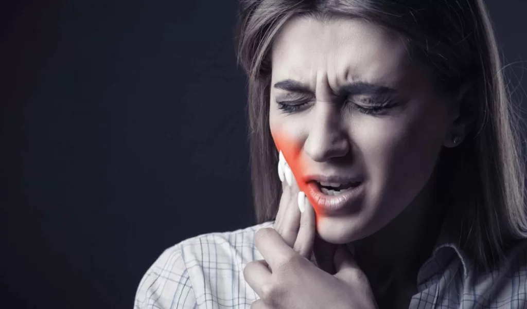 Woman holding both hands over mouth with tooth pain