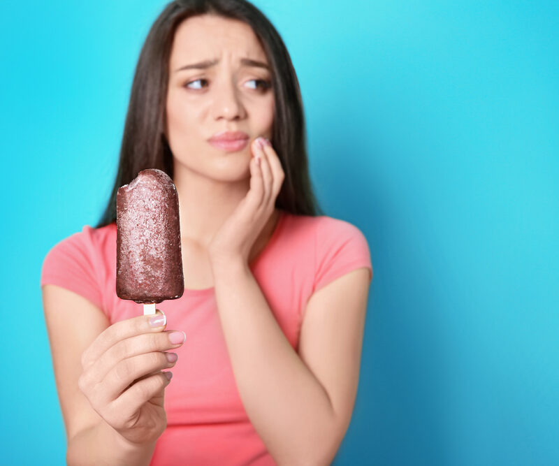 woman with sensitive teeth after biting ice cream
