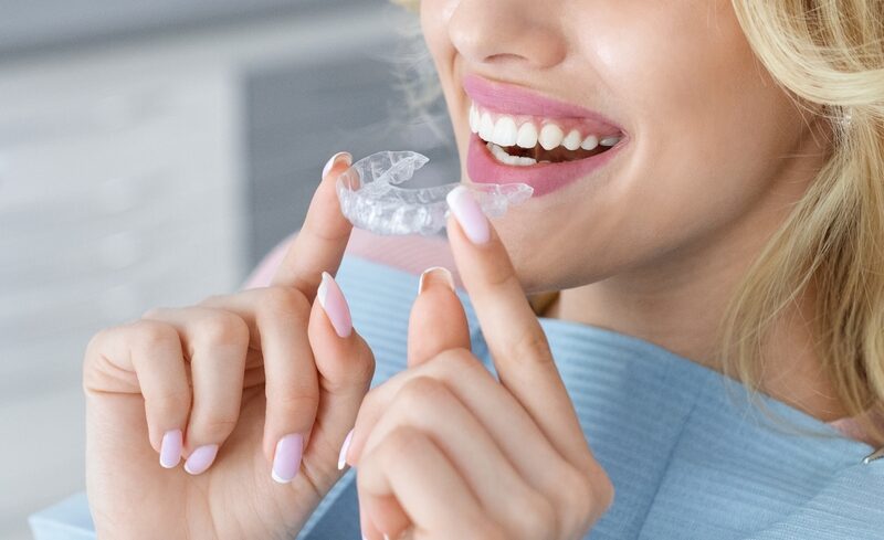 Woman putting on invisalign clear aligners